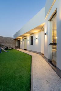 ein großer Innenhof mit grünem Rasen in einem Gebäude in der Unterkunft Casa Viña Sol - Vive la ruta del Vino y del Pisco in Ica + 60 Fotos