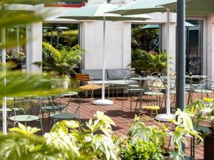 a patio with chairs and tables and an umbrella at ibis Rouen Centre Champ de Mars in Rouen