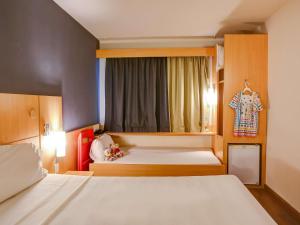une chambre d'hôtel avec deux lits et une fenêtre dans l'établissement ibis Rio de Janeiro Santos Dumont, à Rio de Janeiro 80 autres photos