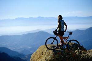 a woman standing on top of a mountain with a bike at Penthouse Bandarawela in Bandarawela