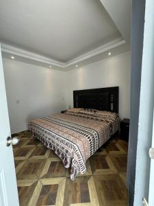 a bedroom with a bed with a comforter on the floor at Hotel Real Mixteca in Huajuapan de León