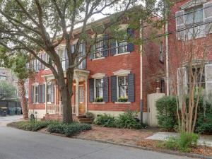 a red brick house with a tree in front of it at Luxury on Lincoln in Savannah