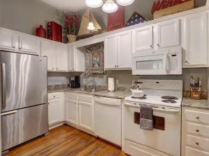 a white kitchen with white appliances and white cabinets at Southern Hall Lower in Savannah