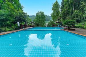 einem Pool mit Reflexion im Wasser in der Unterkunft Snowy&Sunny Resort Phoenix City Hunan in Fenghuang