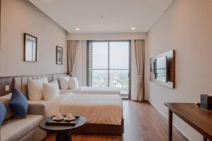 a hotel room with a bed and a couch at Mandala Hotel & Suites Hải Dương in Bảo Thap
