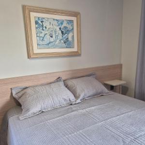 a bedroom with a bed with a picture on the wall at SKY Alphaville in Barueri