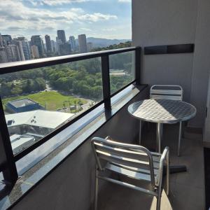a balcony with a table and chairs and a view of a city at SKY Alphaville in Barueri