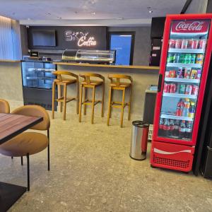 a cocacola soda machine in a restaurant with stools at SKY Alphaville in Barueri