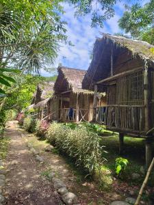 una casa con un tetto di paglia e un sentiero di Lisan Wasi a Indillana