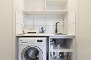 eine Küche mit Waschmaschine und Spüle in der Unterkunft Spacious 1-Bed Townhouse in Norlane in Norlane + 2 Fotos