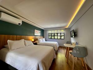 a hotel room with two beds and a table and a table at Ecohousing in Medellín