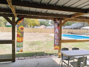 a pavilion with a table and chairs and a pool at The Denham Springs Esape- Pool, Comfort & Charm in Denham Springs