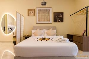 a bedroom with a large white bed and a mirror at KIP Core Soho Suite by Five Senses in Sepang