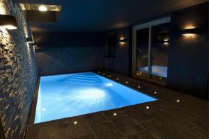 ein großes Schwimmbecken in einem Raum mit blauem Licht in der Unterkunft Superb Chenalette Chalet in Morzine + 16 Fotos