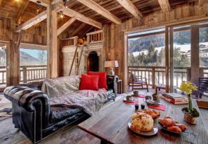 ein Wohnzimmer mit einem Ledersofa und einem Holztisch in der Unterkunft Superb Chenalette Chalet in Morzine