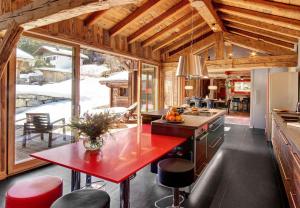 eine Küche mit einem roten Tisch in einer Hütte in der Unterkunft Superb Chenalette Chalet in Morzine