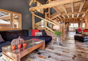 ein Wohnzimmer mit Sofa und Tisch in der Unterkunft Superb Chenalette Chalet in Morzine