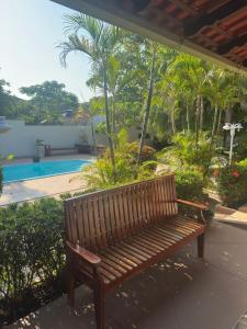 a wooden bench sitting next to a swimming pool at Pousada Alter Villa Suítes in Alter do Chao +41 photos