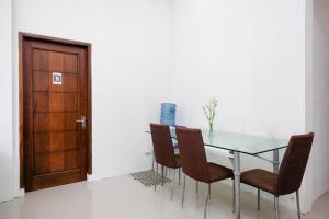 ein Esszimmer mit Glastisch und Stühlen in der Unterkunft RedDoorz Syariah near Pengadilan Agama Wonosobo in Wonosobo