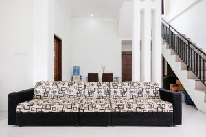 eine Couch in einem Wohnzimmer neben einer Treppe in der Unterkunft RedDoorz Syariah near Pengadilan Agama Wonosobo in Wonosobo