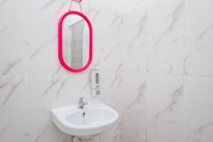 ein Badezimmer mit einem weißen Waschbecken und einem roten Spiegel in der Unterkunft RedDoorz Syariah near Pengadilan Agama Wonosobo in Wonosobo + 86 Fotos