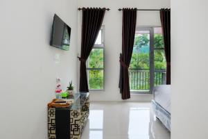 ein Schlafzimmer mit einem Bett und zwei Fenstern in der Unterkunft RedDoorz Syariah near Pengadilan Agama Wonosobo in Wonosobo