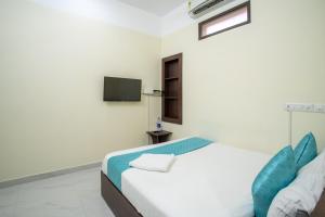 a white room with a bed and a tv at Infinity Rooms Kazhakkoottam Technopark in Trivandrum