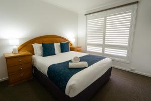 Giường trong phòng chung tại Waves Motel and Apartments formerly Comfort Inn International