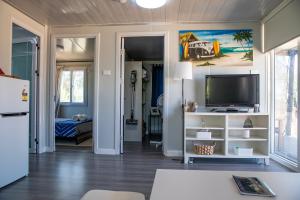 a living room with a flat screen tv and a living room at The Holiday Hut in Lightning Ridge +25 photos