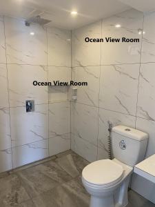 ein Badezimmer mit weißer Toilette und Dusche in der Unterkunft Papa Freds Beach Resort in Puerto Galera