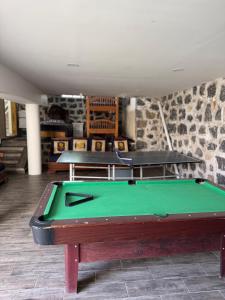 ein Billardtisch in einem Raum mit zwei Tischen in der Unterkunft Casa del Lago in Presa Requena