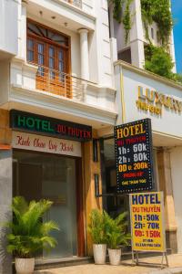 a hotel with signs in front of a building at Du Thuyền Hotel Hồ Chí Minh in Ho Chi Minh City