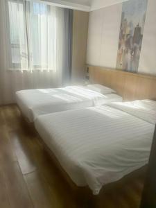 Ένα ή περισσότερα κρεβάτια σε δωμάτιο στο Beijing Northern Langyue Hotel Financial Street Branch