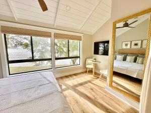 Un dormitorio con una cama y un espejo grande. en Bay Front Near Gulf - Elegant & Private Stay, en Niceville