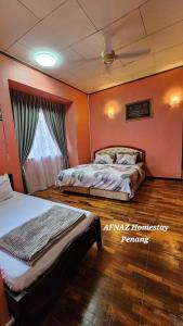 Ένα ή περισσότερα κρεβάτια σε δωμάτιο στο Afnaz Homestay Penang +8 φωτογραφίες