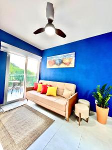 a living room with a couch and a ceiling fan at NOVIDADE! Apartamento Bella Vita Bertioga in Bertioga