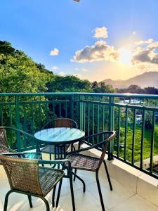 a patio with chairs and a table on a balcony at NOVIDADE! Apartamento Bella Vita Bertioga in Bertioga