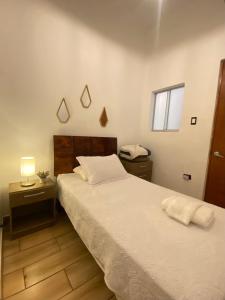 a bedroom with two beds and a lamp and a window at Lince Apartments in Lima