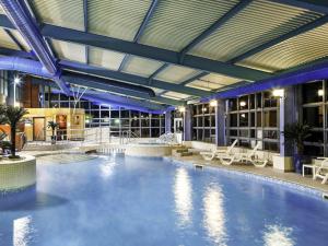 a large swimming pool in a large building at Mercure Chester Abbots Well Hotel in Chester