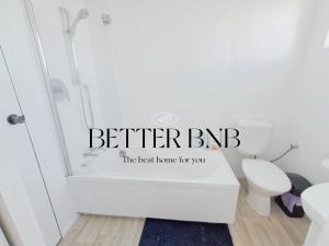 ein Badezimmer mit Dusche und Toilette mit einem Schild, auf dem „Besser brubbn“ steht in der Unterkunft Comfortable Stay for six and Perfect for Families in Lower Hutt + 19 Fotos