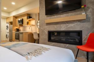 een slaapkamer met een open haard en een tv erboven bij Brand New Canmore Studio - Cozy Mountain Getaway in Canmore
