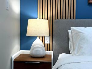 een witte lamp op een houten tafel naast een bed bij Brand New Canmore Studio - Cozy Mountain Getaway in Canmore