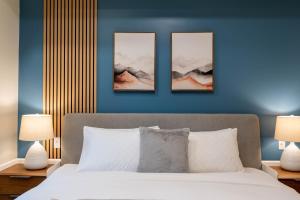 een slaapkamer met drie foto's op een blauwe muur bij Brand New Canmore Studio - Cozy Mountain Getaway in Canmore