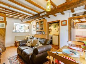 ein Wohnzimmer mit einer Ledercouch und einem Tisch in der Unterkunft 2 bed property in Lechlade 40192 in Langford