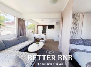 ein Wohnzimmer mit einer Couch und einem Bett in der Unterkunft Comfortable Stay for six and Perfect for Families in Lower Hutt