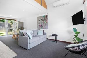 una sala de estar con un sofá y una mesa en Self-contained Studio close to Kensington Park, en Whangarei
