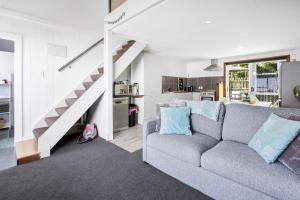 Una sala de estar con un sofá y una escalera. en Self-contained Studio close to Kensington Park, en Whangarei