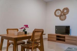 a dining room with a table and chairs and a tv at Adhy Villa Ubud by Bali Cabin in Ubud
