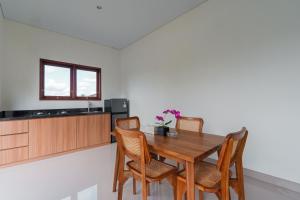 a dining room with a wooden table and chairs at Adhy Villa Ubud by Bali Cabin in Ubud