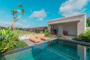 a villa with a swimming pool and a house at Adhy Villa Ubud by Bali Cabin in Ubud